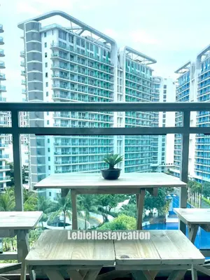 a table with a potted plant on a balcony with buildings at azure urban resort residences in Manila