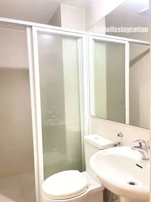 a bathroom with a white toilet and a sink at azure urban resort residences in Manila