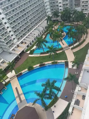 an overhead view of a large swimming pool with palm trees at Shell Residences Condotel Apartment in Manila