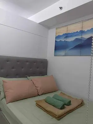 a bed with two pillows on it in a room at Shell Residences Condotel Apartment in Manila