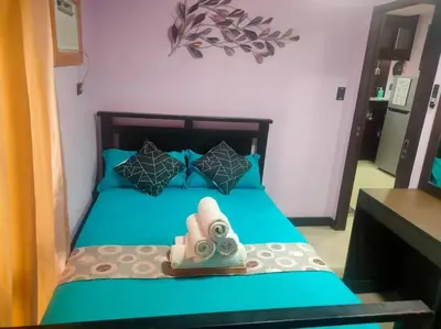 a bedroom with a blue bed with a towel on it at Near Manila Airport COZY 02 Bedroom Condo With Pool - 4R in Manila