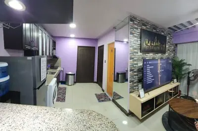 a kitchen with purple walls and a stone wall at Near Manila Airport COZY 02 Bedroom Condo With Pool - 4R in Manila