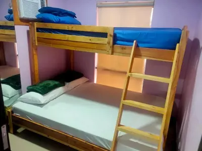 a bunk bed with a ladder in a room at Near Manila Airport COZY 02 Bedroom Condo With Pool - 4R in Manila