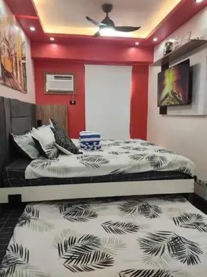 a bedroom with two beds and a red wall at Near Manila Airport COZY HOTEL STYLE Condo With Pool 7A in Manila