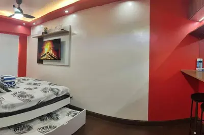 a bedroom with a bed and a red wall at Near Manila Airport COZY HOTEL STYLE Condo With Pool 7A in Manila