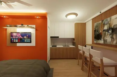 a bedroom with an orange wall and a kitchen at Near Manila Airport, COZY Hotel Style Studio Condo 5G in Manila