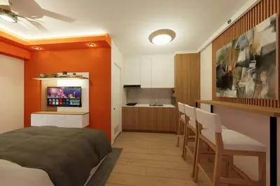 a bedroom with an orange wall and a kitchen at Near Manila Airport, COZY Hotel Style Studio Condo 5G in Manila
