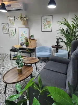 a living room with a couch and tables and plants at Sleep With Me Room cozy stay near Araneta Center in Manila