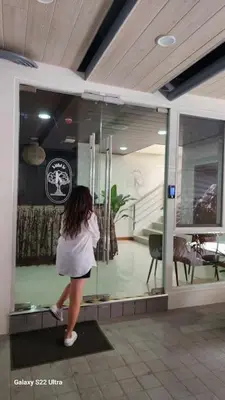 a woman walking in front of a glass window at Sleep With Me Room cozy stay near Araneta Center in Manila