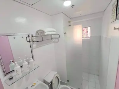 a bathroom with a shower and a toilet and a mirror at Near Manila Airport COZY 01 Bedroom Condo - 10K in Manila