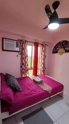 a bedroom with a purple bed and a window at Near Manila Airport COZY 01 Bedroom Condo - 10K in Manila