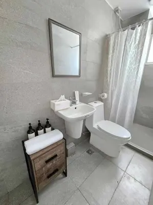 a bathroom with a toilet and a sink and a mirror at Tranquil Haven Relaxing Retreat near Araneta in Manila