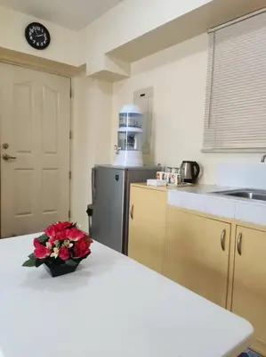 a kitchen with a vase of flowers on a counter at Near Manila Airport COZY Studio Condo With Kitchen 11P in Manila
