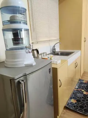 a kitchen with a coffee maker on top of a refrigerator at Near Manila Airport COZY Studio Condo With Kitchen 11P in Manila