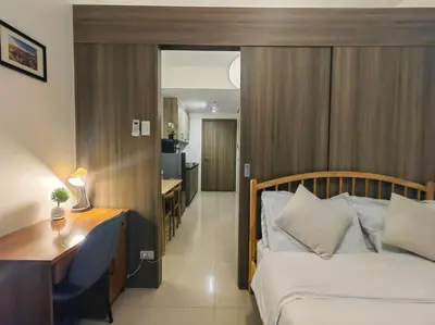 a hotel room with a bed and a desk and a room at 1BR Condotel with Balcony at FAME Residences #FM55 in Manila