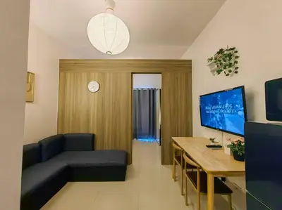 a living room with a couch and a table at 1BR Condotel with Balcony at FAME Residences #FM55 in Manila