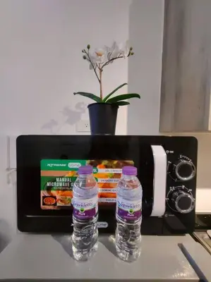 two bottles of water sitting on a counter with a toaster at 1BR Condotel with Balcony at FAME Residences #FM54 in Manila