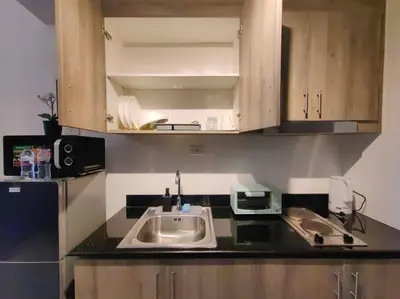 a kitchen counter with a sink and a microwave at 1BR Condotel with Balcony at FAME Residences #FM54 in Manila