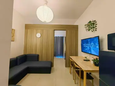 a living room with a couch and a table at 1BR Condotel with Balcony at FAME Residences #FM54 in Manila