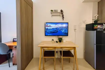 a small table in a kitchen with a refrigerator at 1BR Condotel with Balcony at FAME Residences #FM54 in Manila