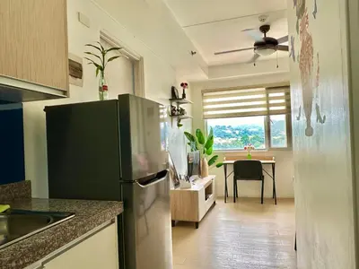 a kitchen with a refrigerator and a table in it at Luna Hive Place in Malapandan