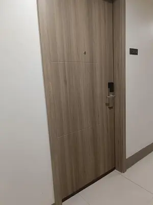 a wooden door in a room next to a wall at Cozy Staycation at Destiny's Crib Fame, Edsa Mandaluyong in Manila