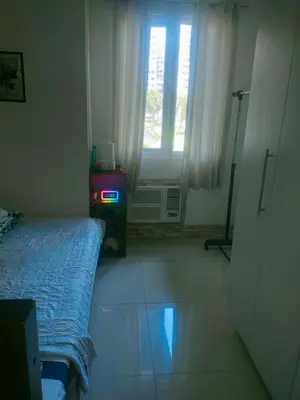a small bedroom with a bed and a window at Sea Residences Condotel GudStay in Manila