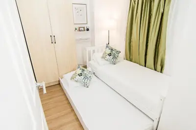 a room with a white couch and a mirror at Excellent Location 2 BDRM Homey Wifi Near Airport in Manila