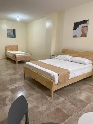 a bedroom with two beds and a chair at W Spot Property in Manila