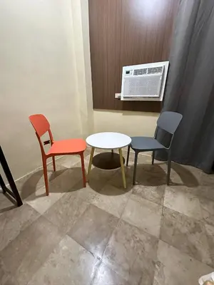 a room with two chairs and a table and a air conditioner at W Spot Property in Manila