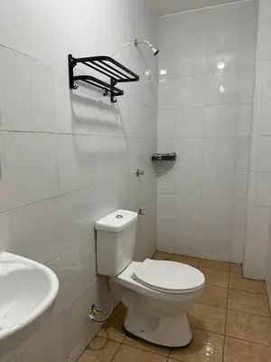 a white bathroom with a toilet and a sink at W Spot Property in Manila