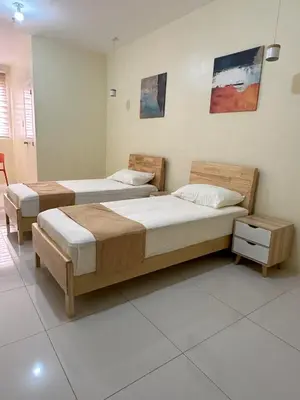 two beds in a room with two tables at W Spot Property in Manila