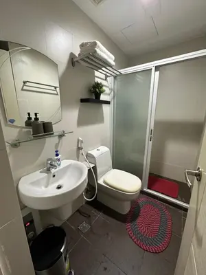 a bathroom with a toilet and a sink and a shower at Cozy Room with Citiview at Greenbelt Makati in Manila