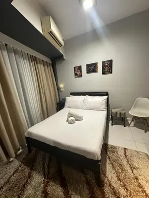 a bedroom with a large white bed in a room at Cozy Room with Citiview at Greenbelt Makati in Manila