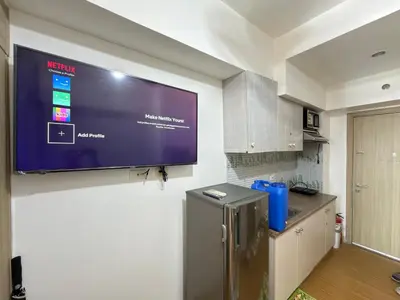 a flat screen tv hanging on a wall in a kitchen at Netflix and Chill at Ephra Homestay - Grace Residences Tower 4 in Manila