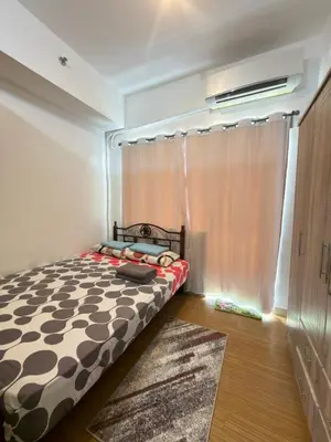 a bedroom with a bed with a curtain and a window at Netflix and Chill at Ephra Homestay - Grace Residences Tower 4 in Manila