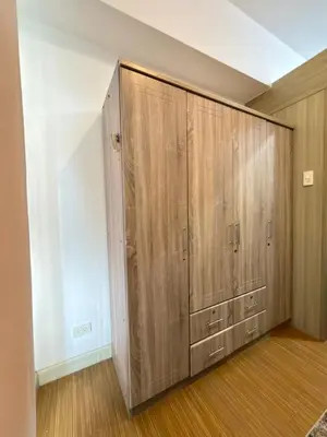 a large closet with wooden cabinets in a room at Netflix and Chill at Ephra Homestay - Grace Residences Tower 4 in Manila