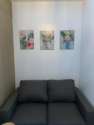 a couch in a room with four pictures on the wall at Netflix & Chill at Pablo's Homestay-Grace Residences Tower 4 in Manila