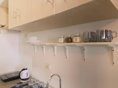 a kitchen shelf with pots and pans on it at Netflix & Chill at Pablo's Homestay-Grace Residences Tower 4 in Manila