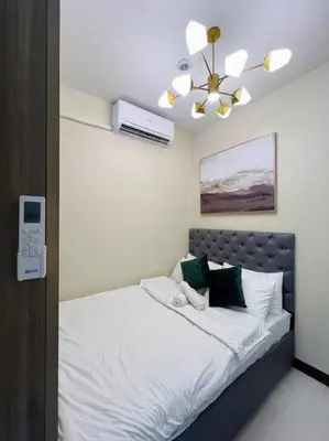 a bedroom with a bed with a ceiling fan at 2BR Solana Suite near MOA PICC NAIA in Manila