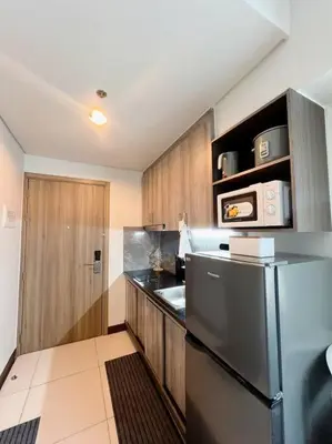 a kitchen with a stainless steel refrigerator and wooden cabinets at 2BR Solana Suite near MOA PICC NAIA in Manila