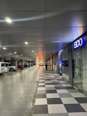 a person walking in an empty parking garage at 2BR Solana Suite near MOA PICC NAIA in Manila
