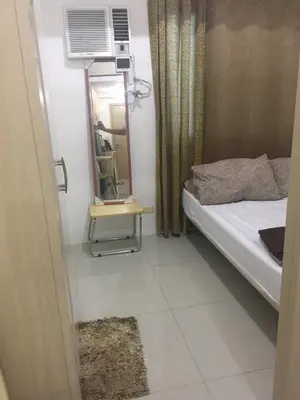 a small room with a bed and a mirror at 20th flr SMDC Lights Residence Mandaluyong City Philippines in Manila
