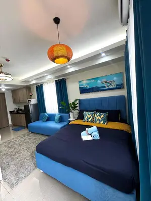 a bedroom with a blue bed and a blue couch at Cloud Place Shore 2 Residences in Manila