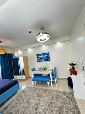 a living room with a table and blue chairs at Cloud Place Shore 2 Residences in Manila