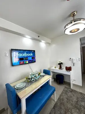 a dining room with a table and blue chairs at Cloud Place Shore 2 Residences in Manila