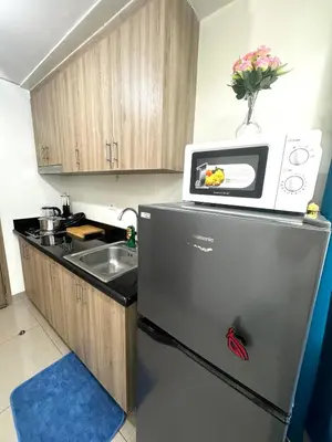 a kitchen with a refrigerator and a microwave on top of it at Cloud Place Shore 2 Residences in Manila