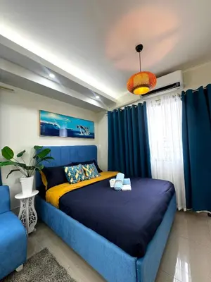 a bedroom with a blue bed and a blue couch at Cloud Place Shore 2 Residences in Manila
