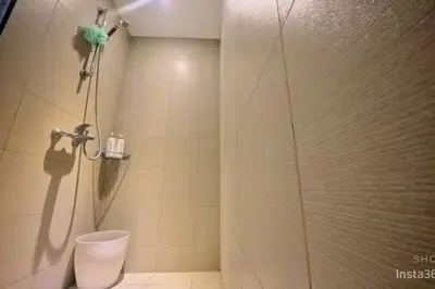 a shower stall with a toilet in a bathroom at Azure staycationbyGetwellwander in Manila
