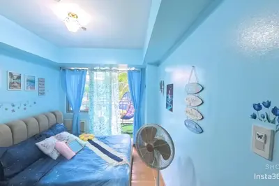 a blue room with a bed and a fan at Azure staycationbyGetwellwander in Manila